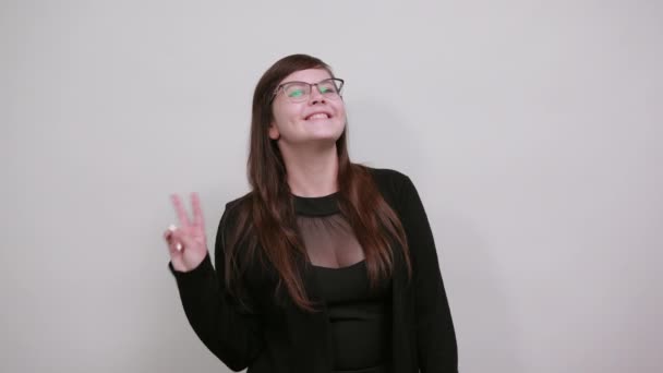Portrait de jeune femme excitée en chemise décontractée noire montrant geste de victoire . — Video