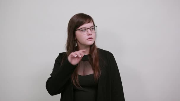 Retrato de una hermosa joven en bonitas gafas sosteniendo y mirando el cabello — Vídeo de stock