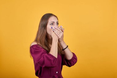 Genç kız elleriyle ağzını kapatıyor.