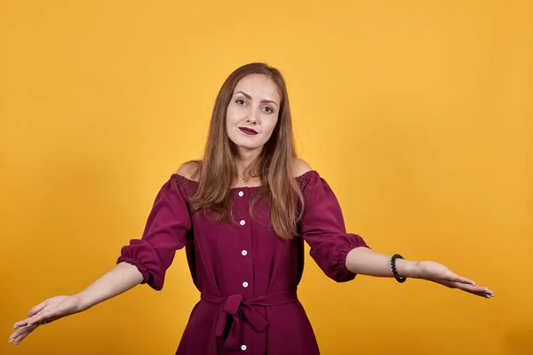 Женщина с длинными волосами впереди изолированная оранжевая стена не знает, что делать — стоковое фото