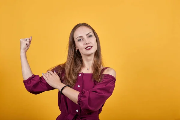 Женщина с длинными волосами впереди изолированная оранжевая стена делает сильный жест — стоковое фото