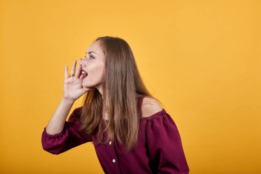 Genç bir kadın ağzı açık bağırıyor.