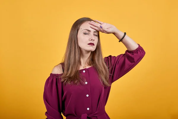 Frau vor Hintergrund hält ihre Hand auf die Stirn mit müdem und krankem Gesichtsausdruck — Stockfoto