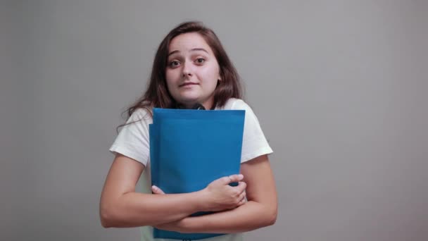 Mujer alegre en camisa blanca sosteniendo carpeta azul, manteniendo la mano en la frente — Vídeos de Stock