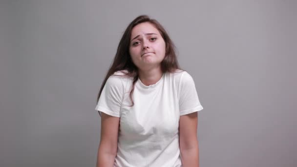 Mujer decepcionada en la moda camisa blanca extiende las manos, buscando infeliz — Vídeos de Stock
