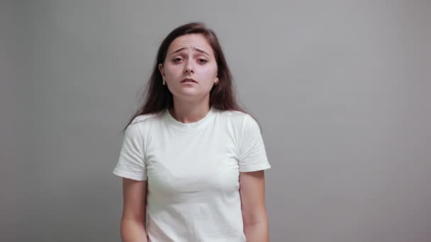 Несчастная белая женщина в моде белая рубашка кусает гвоздь, выглядит смущенно — стоковое видео