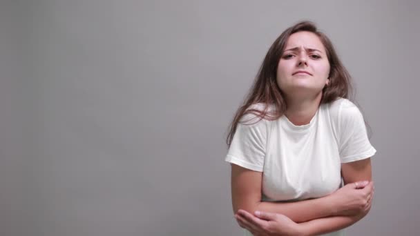 Boldogtalan nő fehér ingben tartja a kezét az övön, fájdalma van az izmokban — Stock videók