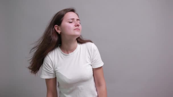 Mujer seria en camisa blanca manteniendo la mano cerca de la oreja, escuchando, chismosa — Vídeos de Stock