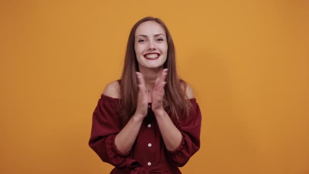 Encantadora mujer en vestido granate aplaude, señalando los pulgares a un lado . — Vídeos de Stock