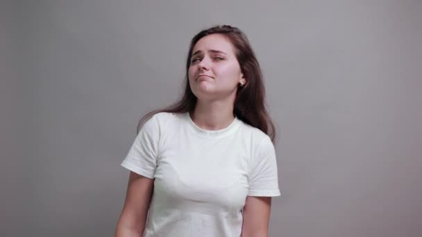 Hayal kırıklığına uğramış beyaz gömlekli beyaz kadın dilini gösteriyor. — Stok video
