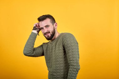 Genç adam kameraya bakıyor, ellerini kafasından ayırmıyor, model.