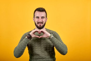 Mutlu yakışıklı beyaz adam kalp şeklinde, güzel görünüyor, gülümsüyor.