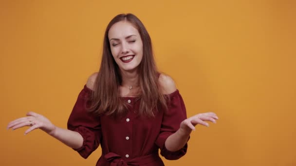 Cheerful lady in fashion maroon dress looking directly, spreads hands, smiling — 图库视频影像