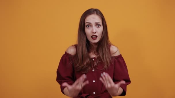 Mujer en vestido granate señalándose las palmas a sí misma, sonriendo, mirando a la cámara — Vídeos de Stock