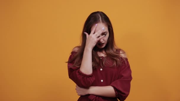 Mujer decepcionada en vestido granate manteniendo los dedos en la cabeza, como arma — Vídeos de Stock