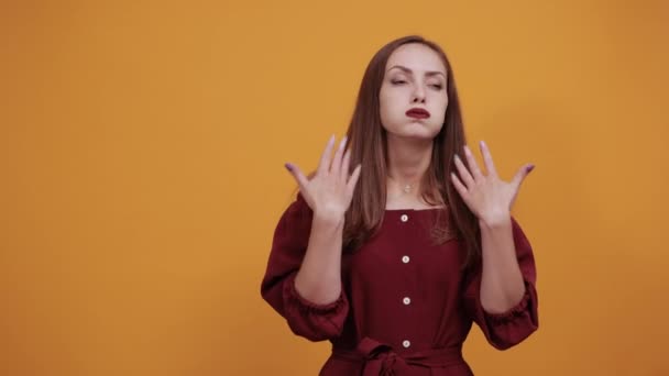 Femme en robe marron en studio agitant les mains, parce que chaud . — Video