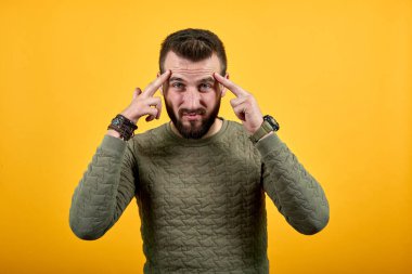 Yakışıklı adam parmaklarını başının üstünde tutuyor, konuyu düşünüyor, başı ağrıyor.