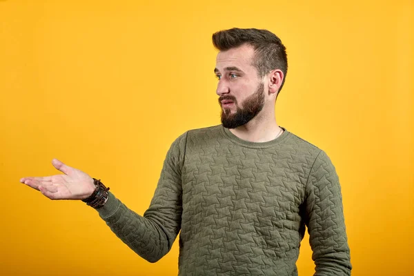 Junger gutaussehender kaukasischer Mann zeigt mit Handfläche zur Seite und sieht ruhig aus — Stockfoto