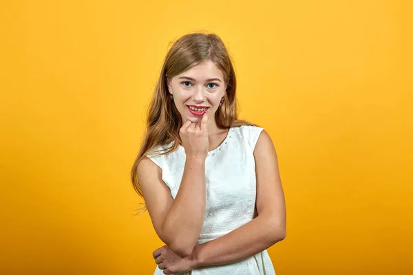 Encantadora rubia joven caucásica manteniendo la mano en la barbilla, sonriendo —  Fotos de Stock