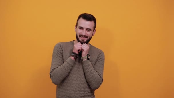 Красивый мужчина держит руки на щеках, борода, улыбается, выглядит счастливым — стоковое видео
