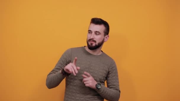 Feliz hombre caucásico alegre sobre aislado muro naranja señalando a un lado, sonriendo — Vídeos de Stock