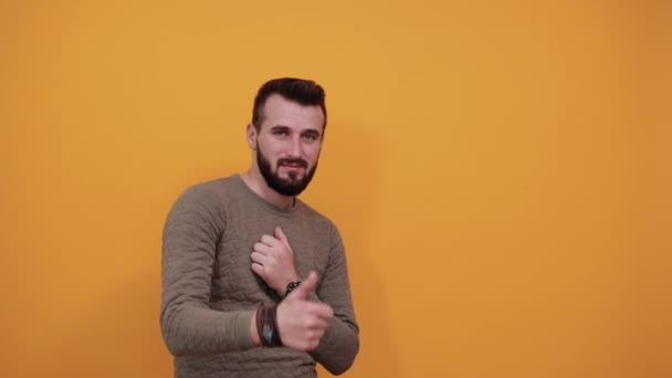 Hombre alegre mirando a la cámara, manteniendo los pulgares hacia arriba, sosteniendo la mano en el pecho — Vídeo de stock