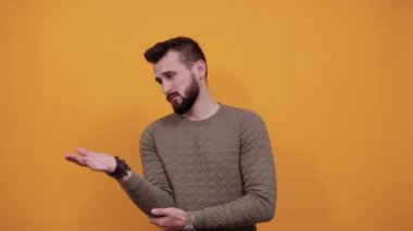 Avuç içlerini gösteren yakışıklı beyaz bir adam, sakin görünüyor.