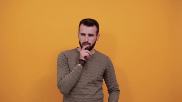 Mladý veselý muž dívající se do kamery, držící ruku na bradě, pěkný — Stock video