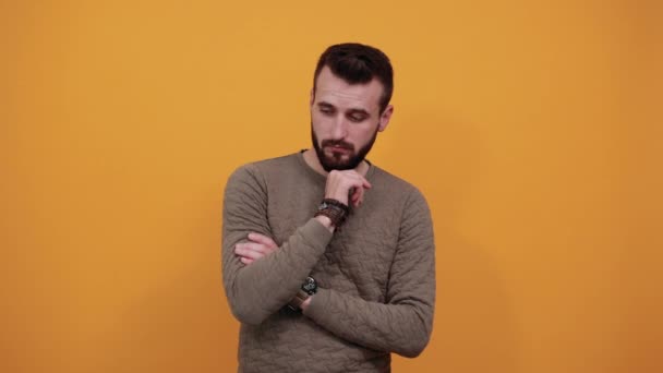 Unshaven handsome man looking at camera, keeping hand on his chin — Stock Video