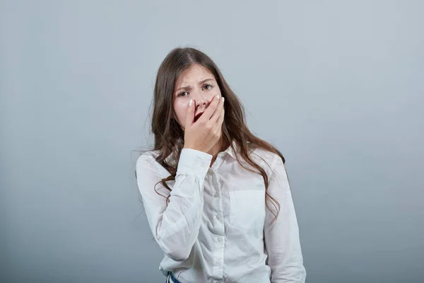 Mujer aburrida en camisa blanca de moda, cogida de la mano en la boca, somnolienta — Foto de Stock