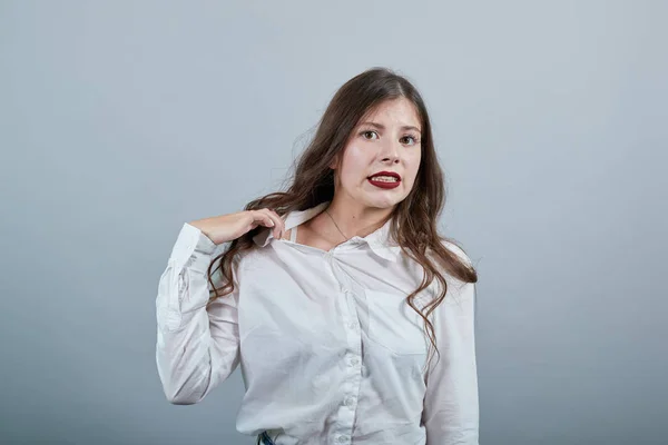 Deluso giovane donna nella moda camicia bianca tenendo mano sulla camicia, soffocamento — Foto Stock