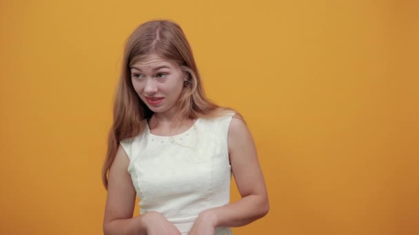 Потрясенная кавказская молодая женщина держит руку на ухе, слушая что-то — стоковое видео