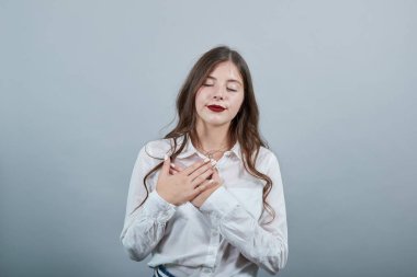 Çekici bir kadın el ele tutuşup, gözleri kapalı göğsü kesiştirip eğleniyor.