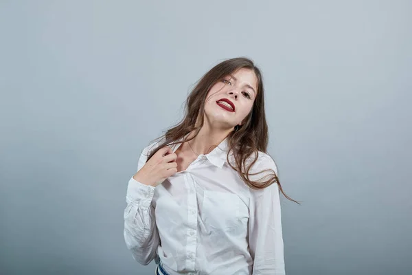 Caucasico giovane bruna donna tira indietro la camicia, guardando grave . — Foto Stock