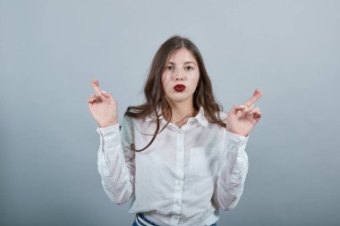 Kafkasyalı esmer kadın parmaklarını çapraz yapıyor, dilek tutuyor, göz kırpıyor..