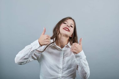 Kafkasyalı neşeli, esmer kadın başparmağını kaldırmış, mutlu görünüyor.