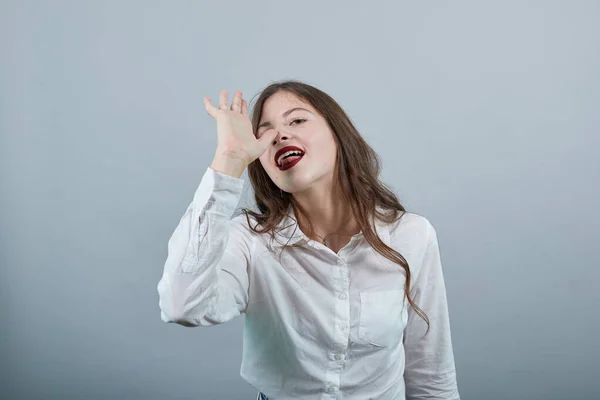 Привлекательная женщина в моде белая рубашка держа руку на носу, делая глупый жест — стоковое фото