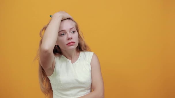 Шокована молода жінка тримає руку на лобі, дивлячись на щось страшне — стокове відео
