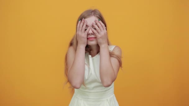 Bájos szőke fiatal nő eltakarja a szemét kézzel, csalódottan néz — Stock videók