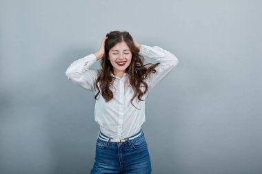 Neşeli kadın el ele tutuşuyor, saç kesimini düzeltiyor, gülümsüyor, eğleniyor.