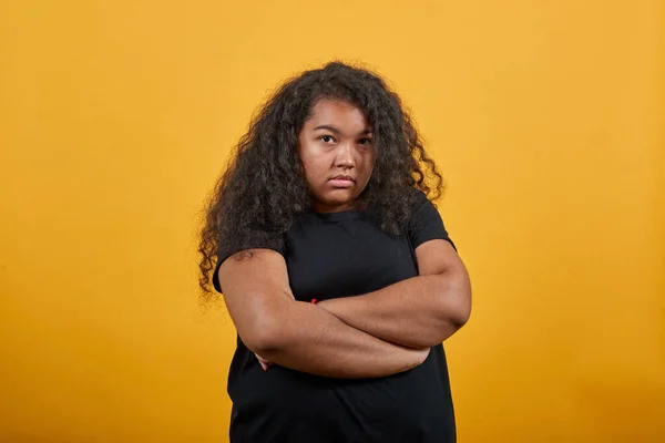 Disappointed woman with overweight keeping hands crossed, looking at camera