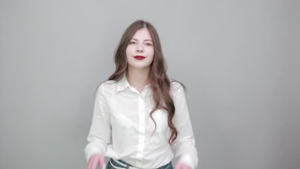 Vonzó fiatal nő, fehér ingben, hüvelykujjal mutogatva magára. — Stock videók