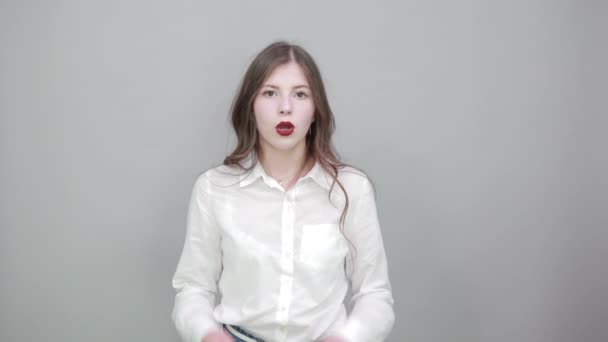 Chockad kvinna pekar hand på kind med öppnad mun, tittar på kameran — Stockvideo
