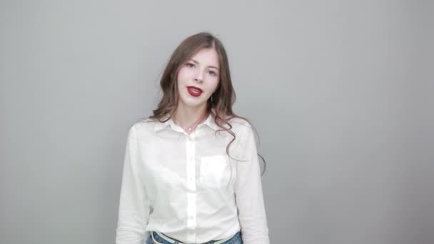 Attractive young woman in fashion white shirt pointing thumbs at camera — Stock Video