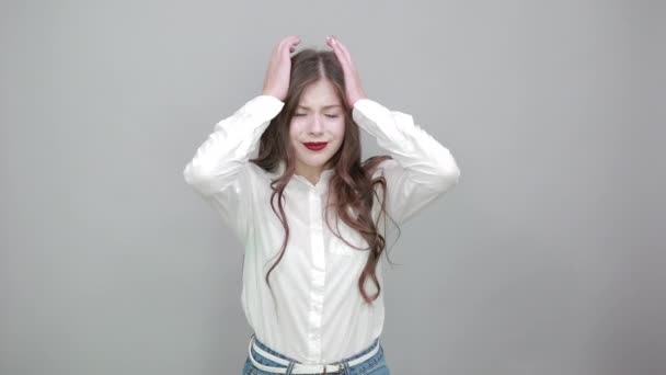 Δυστυχισμένη νεαρή γυναίκα στη μόδα λευκό πουκάμισο κρατώντας το χέρι στο κεφάλι, έχοντας πονοκέφαλο — Αρχείο Βίντεο