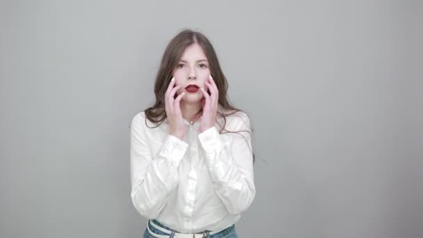 Charming caucasian young woman in fashion white shirt isolated on gray wall — Stock Video