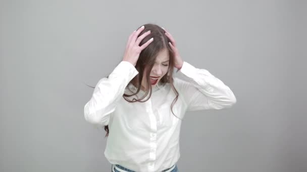 Glimlachende vrouw in wit shirt die hand op hoofd houdt, schreeuwt, er gelukkig uitziet — Stockvideo