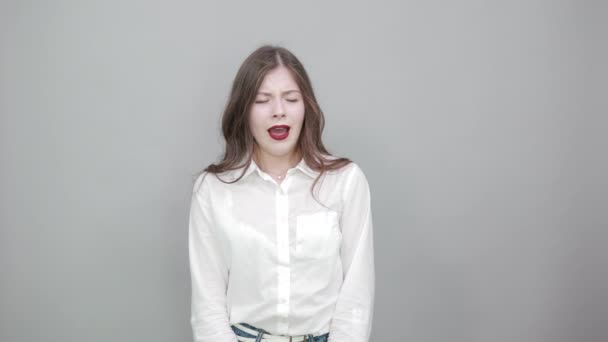 Mujer aburrida en camisa blanca de moda bostezando, cogida de la mano en la cabeza, soñolienta — Vídeos de Stock