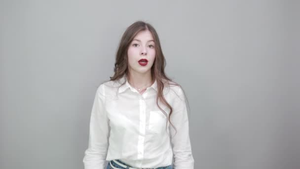 Vit ung brunett kvinna drar tillbaka sin skjorta, ser allvarlig — Stockvideo
