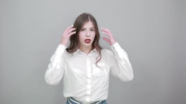 Glada kvinna håller händerna på huvudet, korrigerar frisyr, tittar på kameran — Stockvideo